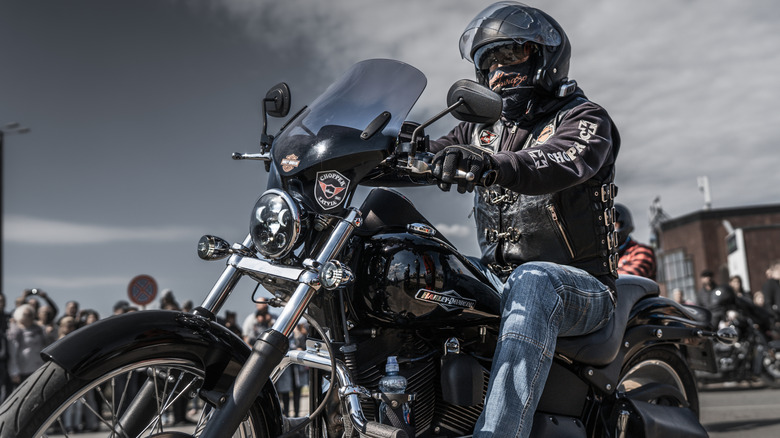 A man wearing a helmet riding a black Harley-Davidson bike