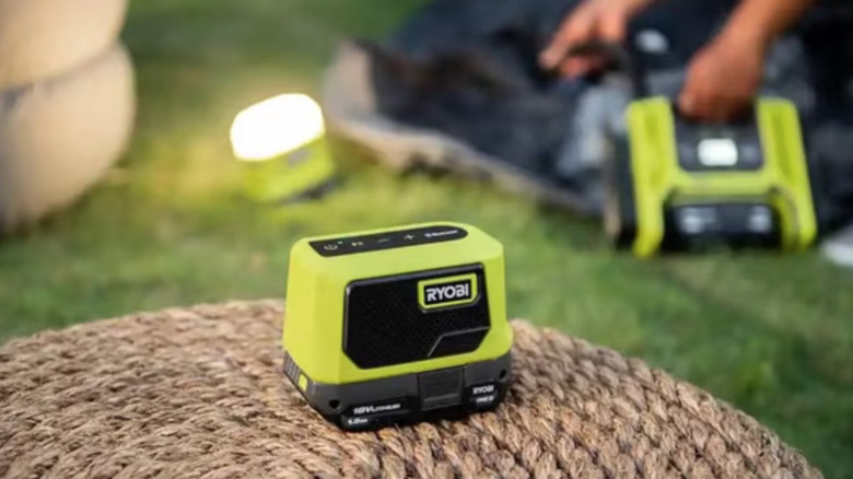 Speaker, light, and other Ryobi accessories at campsite