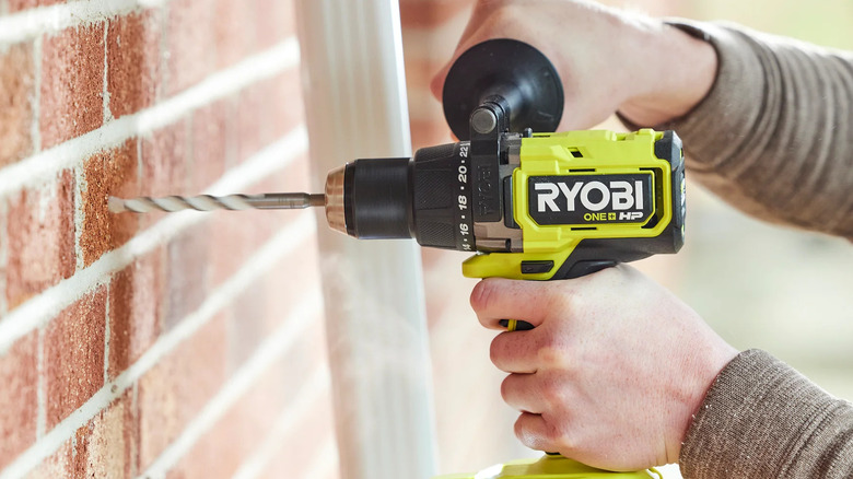Closeup of a Ryobi enthusiast using a hammer drill