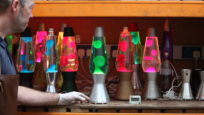 A man testing a wall of lava lamps