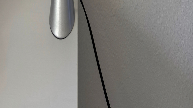 A blue and green lava lamp against a white wall