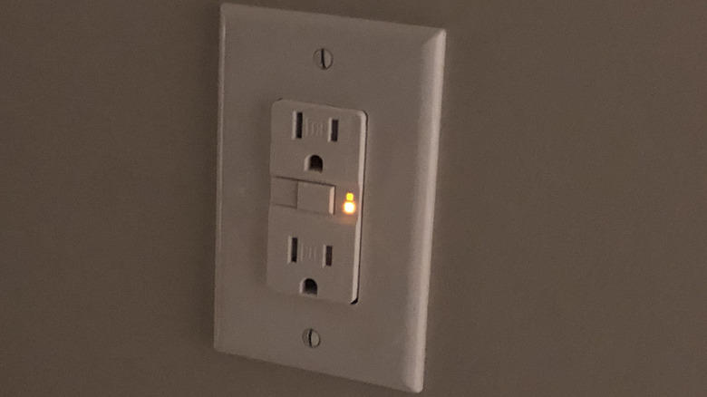 A GFCI power outlet flashes orange