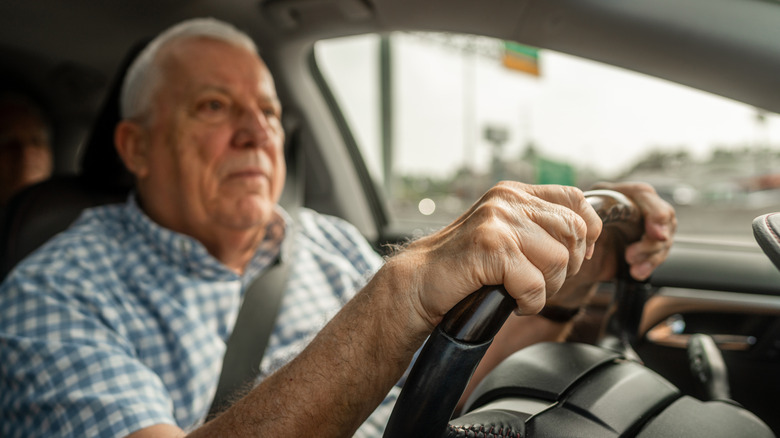 elderly man driving in car
