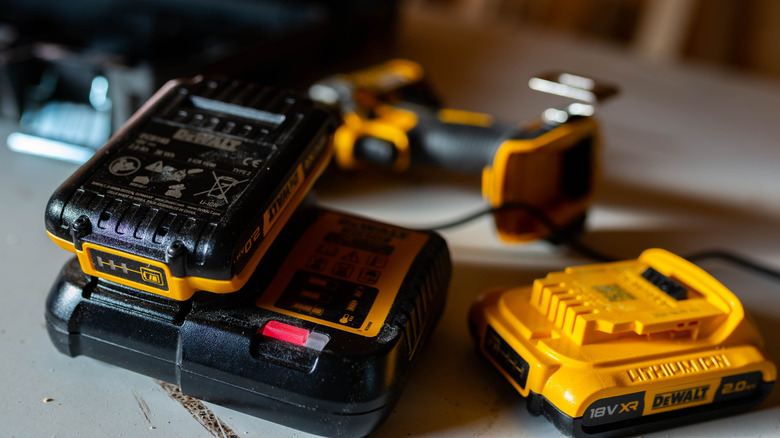 A Dewalt lithium-ion battery charging in a small woodworking shop.