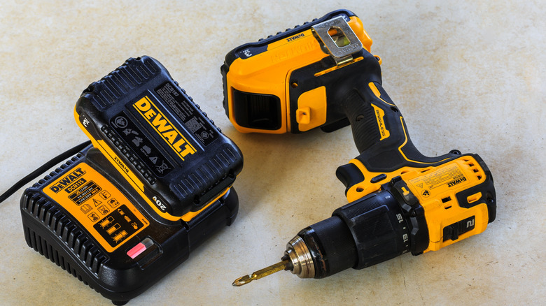 Dewalt Cordless Hammer Drill-Driver with battery charger and second battery on Cement board backgroun