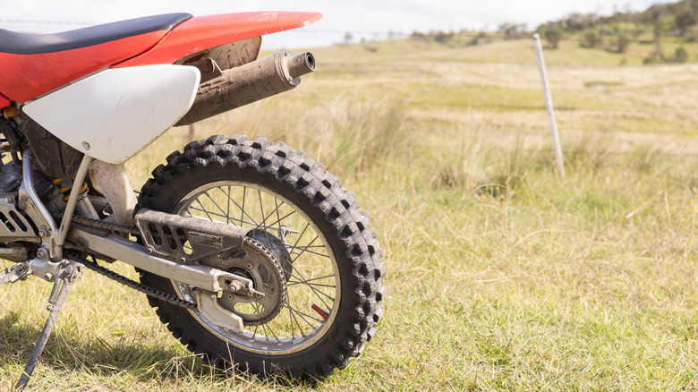 Back of dirt bike parked in grassy field