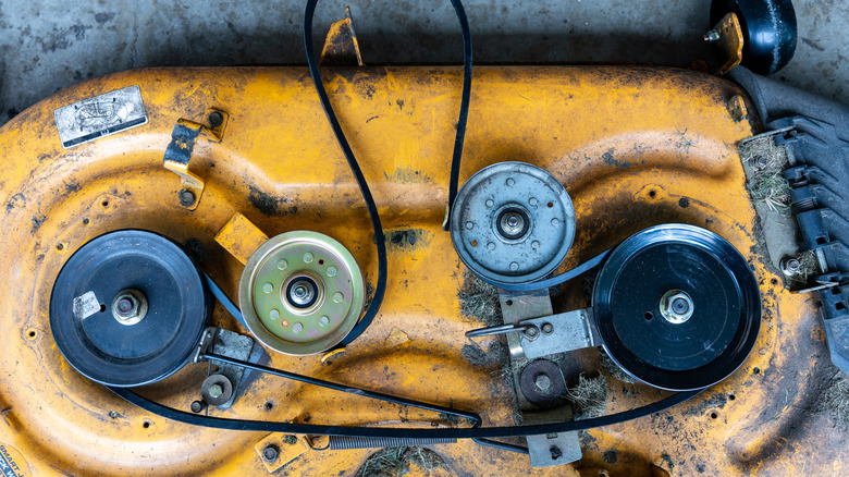 Close-up of belts on a mower deck.