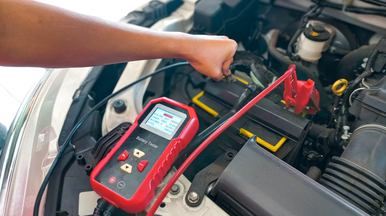 A mechanic testing a car battery