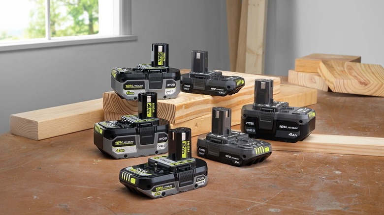 Different Ryobi power tool batteries with cut wood