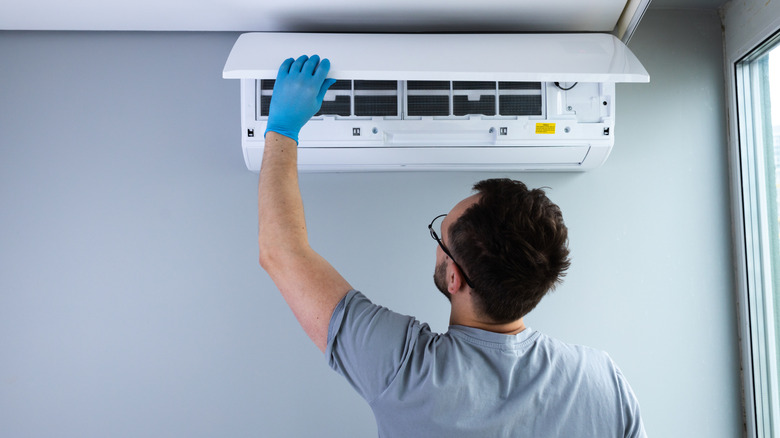 A skilled technician performing maintenance on a ceiling-mounted air conditioning unit