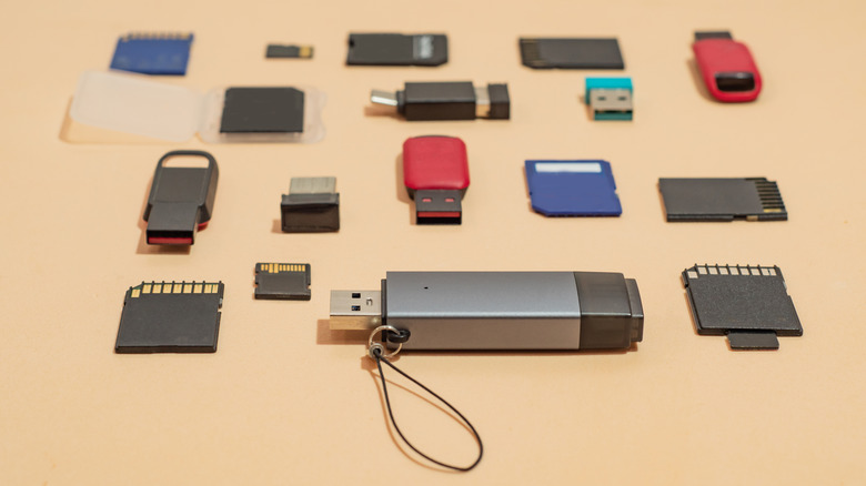 A bunch of USB drives and SD cards on a surface