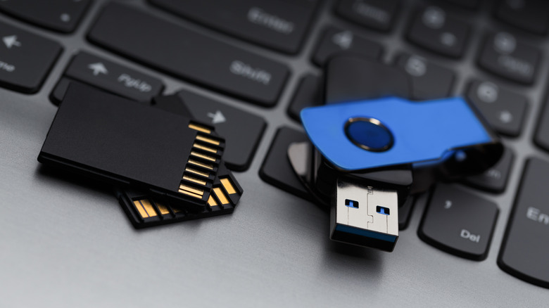An SD card and a USB drive on a laptop keyboard