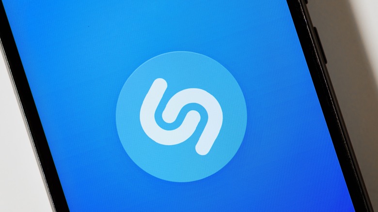 Close up image of the Shazam logo on a blue background on a smartphone screen