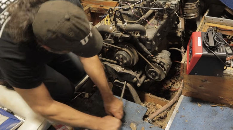 A mechanic rotates the crank to free up a seized engine