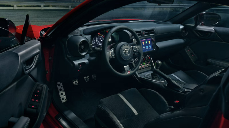 Shot of the Toyota GR86 interior showing the cockpit and dashboard as seen from the driver's side door