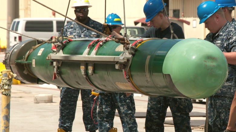 Sailors working on a Mk. 48 Heavyweight Torpedo on a pier