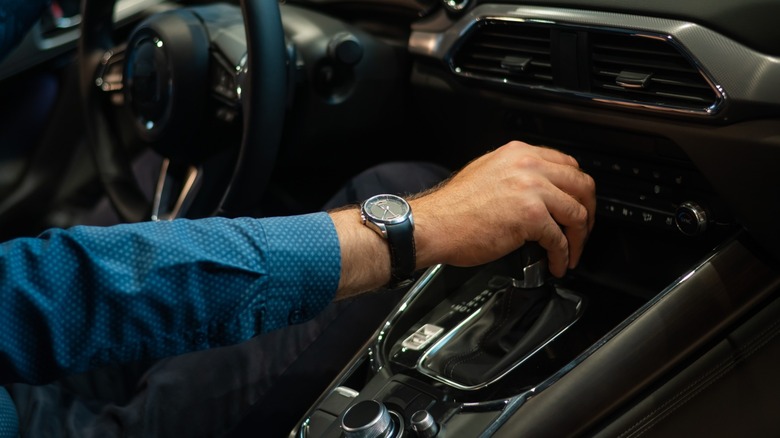 Close-up of a man's hand while shifting the automatic transmission of a car