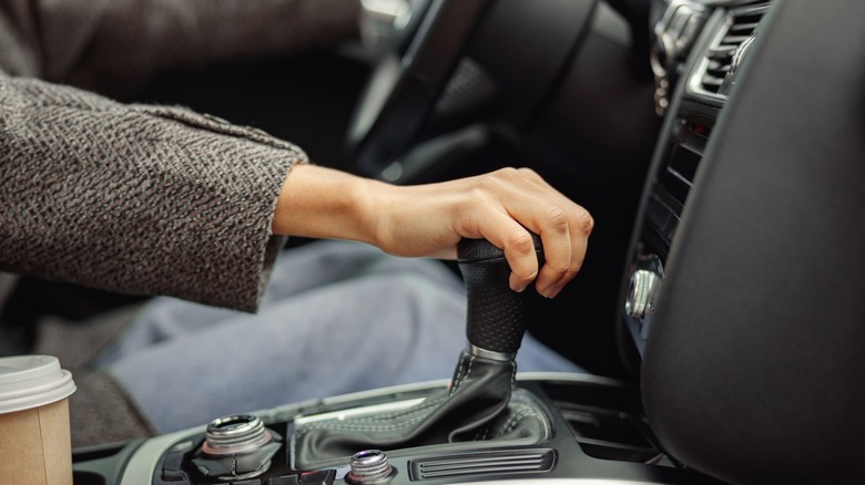 Close up of woman controlling gearbox in the car