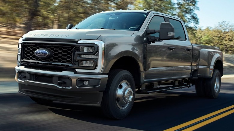 The 2026 Ford Super Duty pickup in gray traveling at speed on a country road