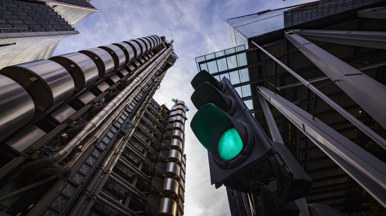 A wide-angle shot of a traffic light in London with a bunch of high-rise buildings in the background