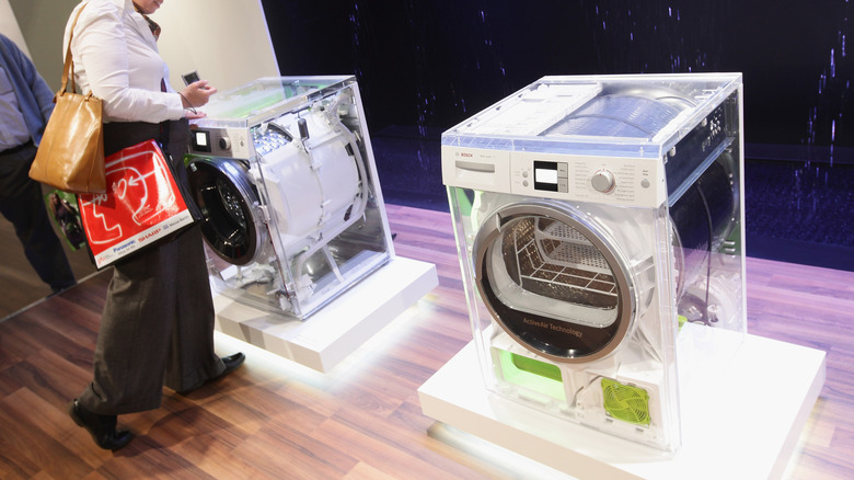 A person examining Bosch energy-efficient washing machines at the IFA trade show