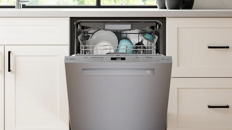 A Bosch Benchmark dishwasher installed and partially open in a luxury kitchen