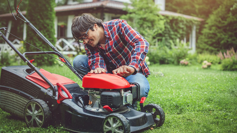 Person looking at their lawn mower and smiling