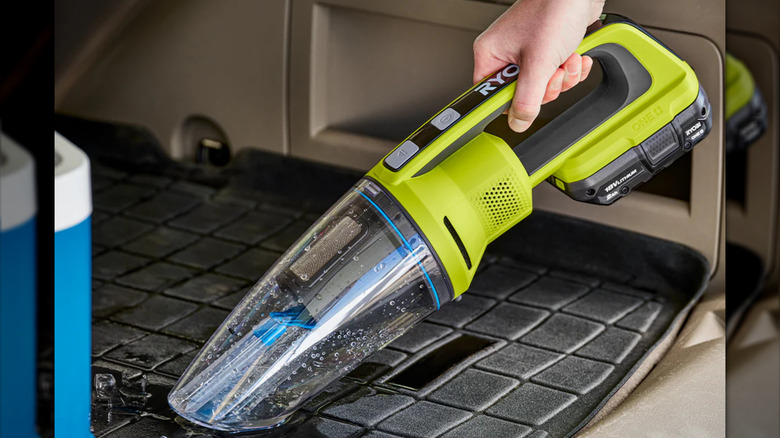 Hand vacuum removing water from a car mat