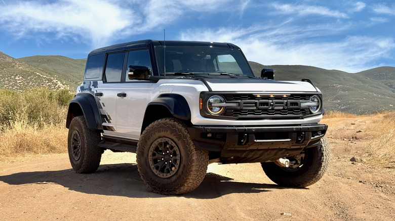 White Ford Bronco Raptor parked off road with mountains in the distance