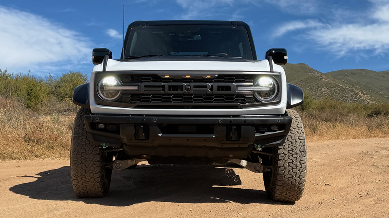 Front view of white Ford Bronco Raptor parked on a dirt road