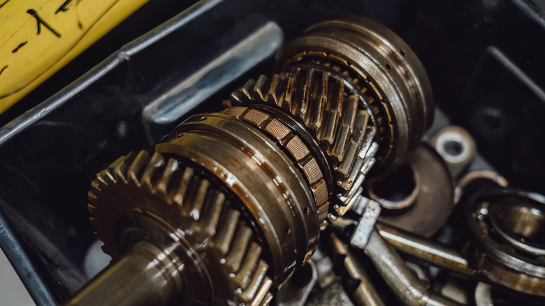 Disassembled manual transmission main shaft showing lubricated gears