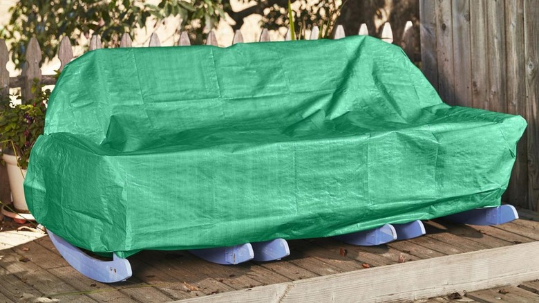 Green tarp covering outdoor furniture