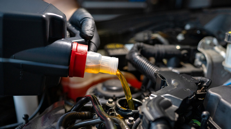 Close-up of engine oil being poured into a modern car engine
