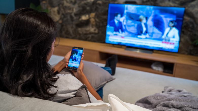 Person mirroring phone on TV