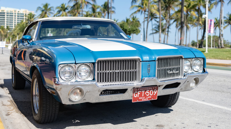 Blue Cutlass Supreme on sunny street