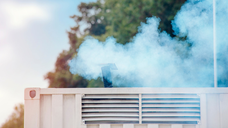 Plumes of greyish blue smoke coming from a diesel generator.