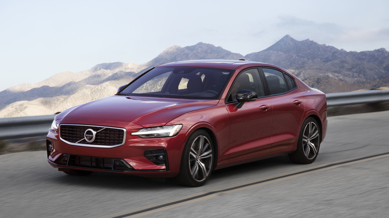 A front-left view of a 2018 Volvo S60 sedan traveling on a mountain road