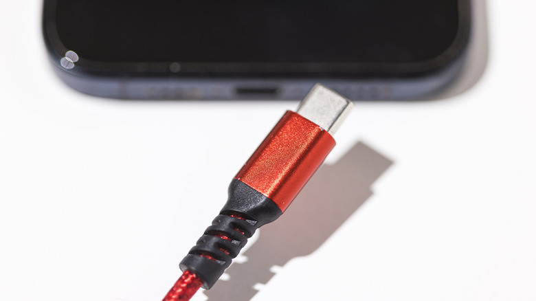 Red USB-C connector next to smartphone