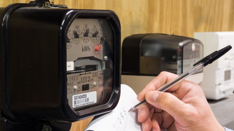 Hand writing down reading from an electrical meter
