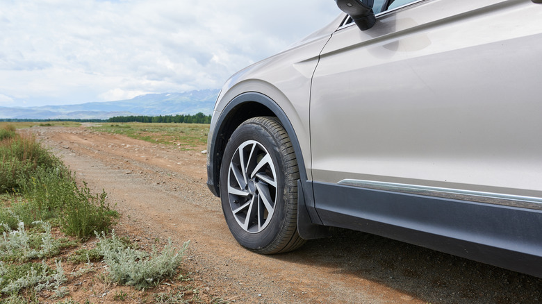 A car on a dirt road in a rural area