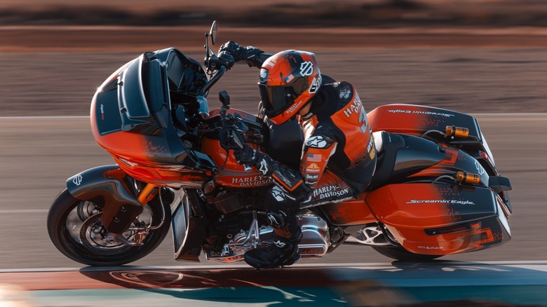 A Harley-Davidson rider leaning into a corner on a race track riding the 2025 Harley-Davidson CVO Road Glide RR.