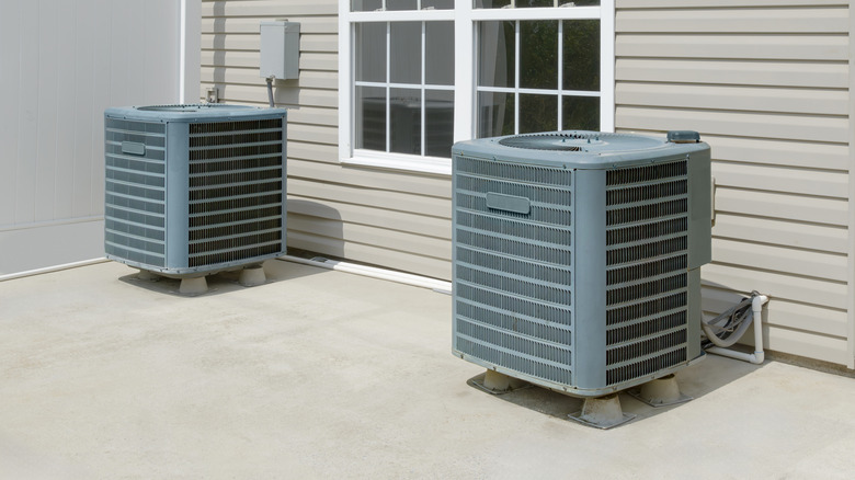 Two air conditioner units spaced far apart outside of a home