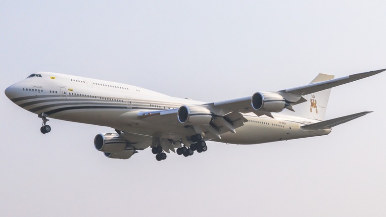 White Boeing 747-8i flying in the air with the emblem of the Sultan of Brunei