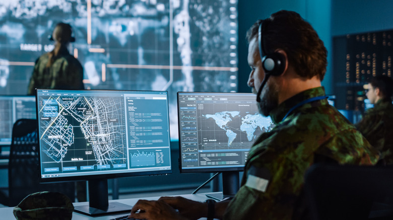 Military Surveillance Officer Working on a City Tracking Operation in a Central Office Hub for Cyber Control and Monitoring for Managing National Security, Technology and Army Communications.