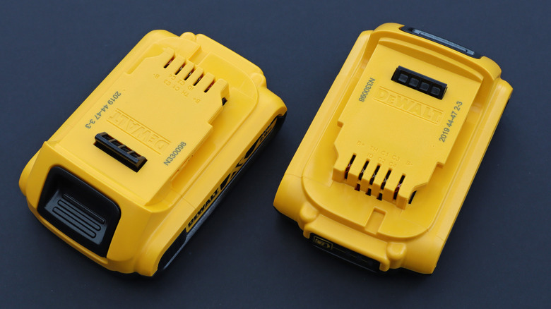 Two DeWalt batteries on a surface.