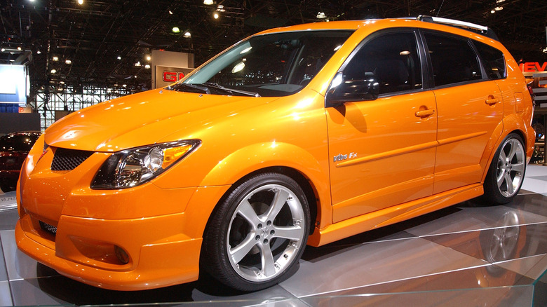 An orange Pontiac Vibe on display at an auto show.