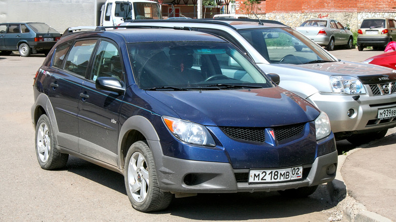 A blue Pontiac Vibe parked alongside other vehicles