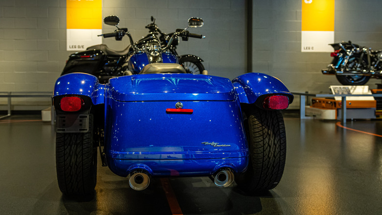 A blue Harley-Davidson sidecar motorcycle is showcased in the service area of a store in Pittsburgh.