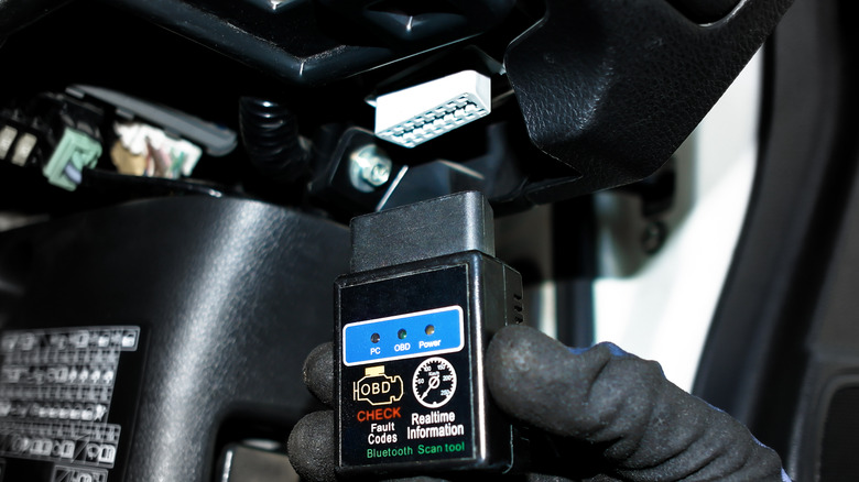A mechanic holding OBD II scanner