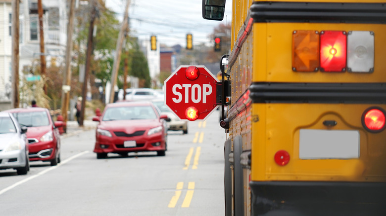stopped school bus with illuminated stop sign and stopped oncoming traffic